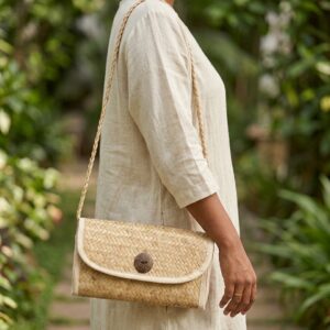 Woman carrying a handcrafted woven natural fiber shoulder bag in eco friendly dress